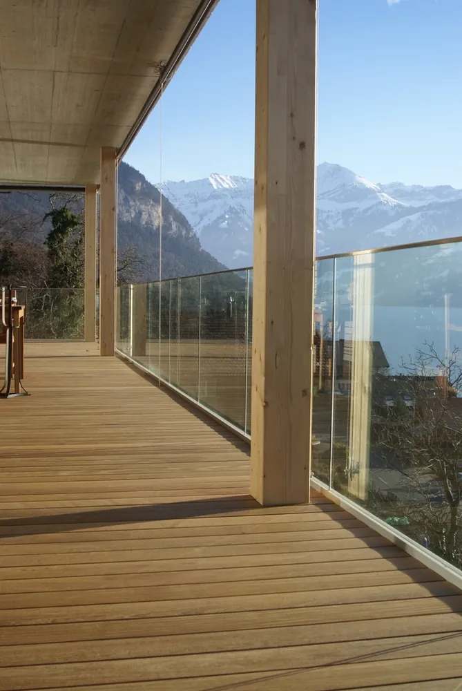 Covered timber deck with glass railing and mountain view